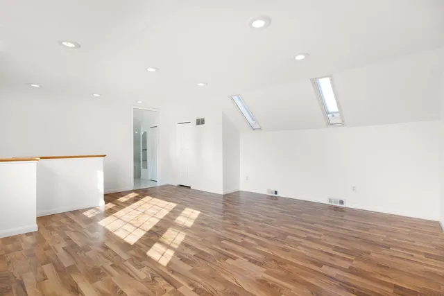 a view of an empty room with wooden floor