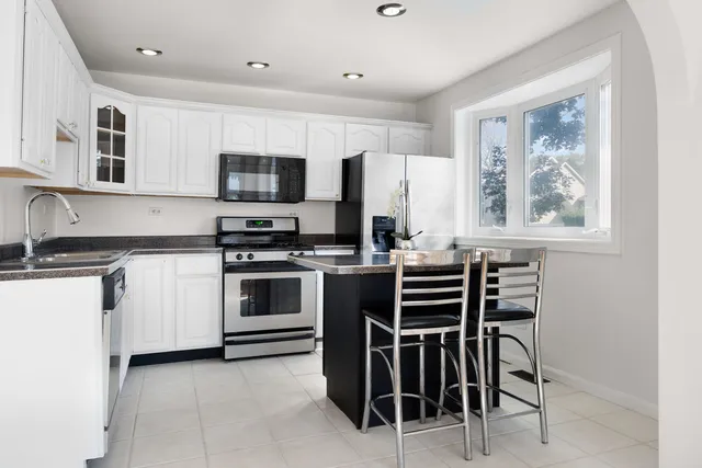 a kitchen with stainless steel appliances a stove sink microwave and cabinets