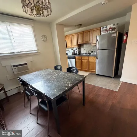 a kitchen with granite countertop a refrigerator a stove a sink and a dining table