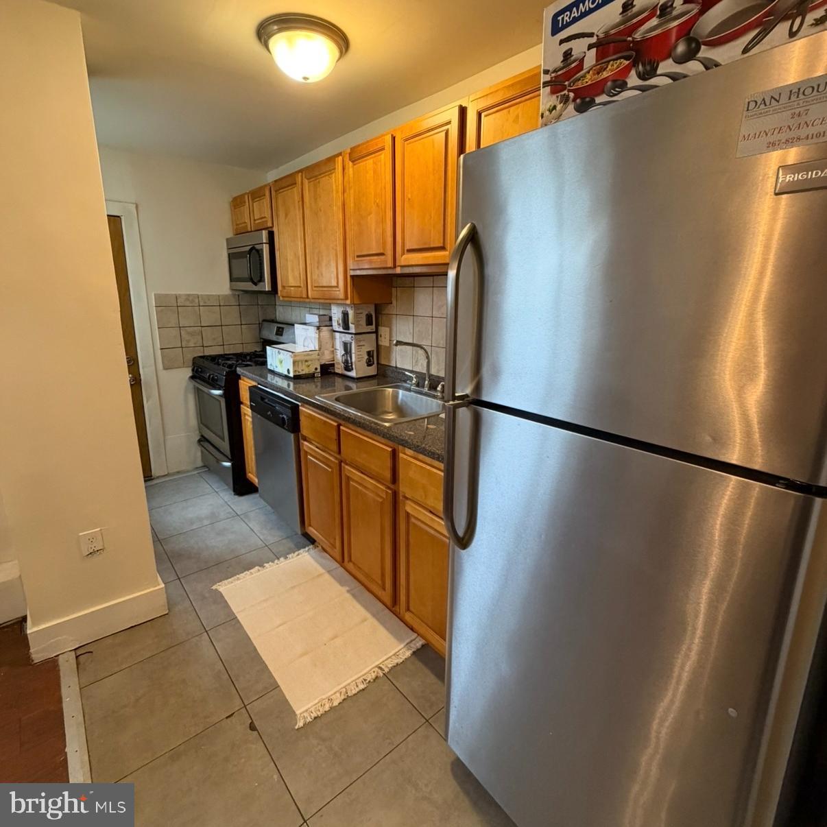 929 Edgemore Road Philadelphia, PA 19151 - Photo 4 of 16 a kitchen with stainless steel appliances granite countertop a refrigerator a sink a stove a washer dryer and a refrigerator
