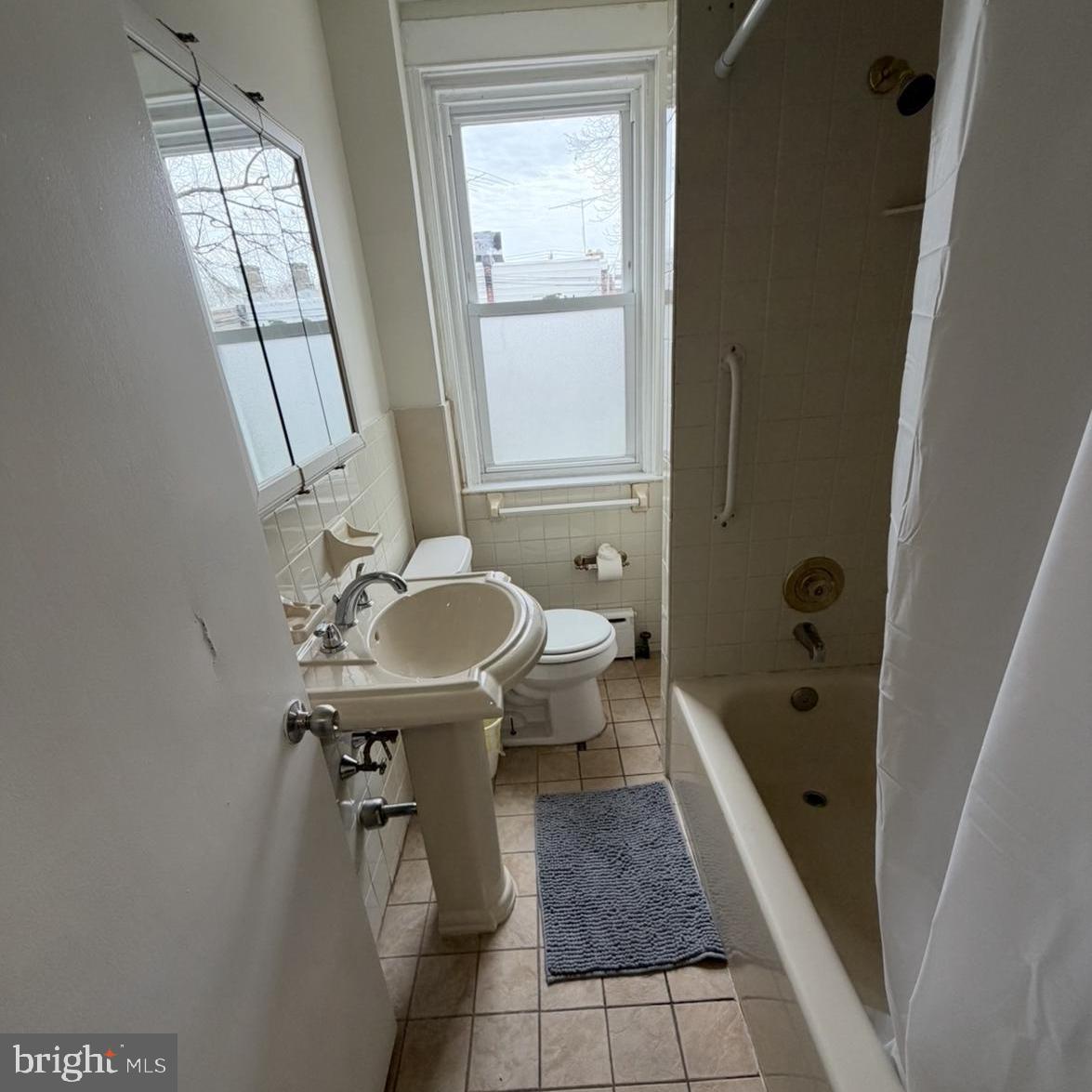 929 Edgemore Road Philadelphia, PA 19151 - Photo 6 of 16 a bathroom with a sink a toilet and shower