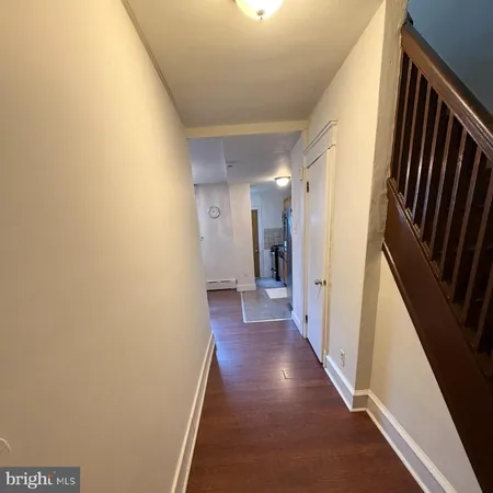 a view of a hallway with wooden floor