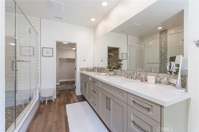 a bathroom with a double vanity sink mirror and shower