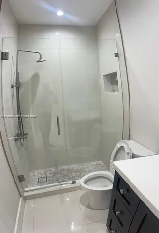 a bathroom with a granite countertop sink toilet and shower