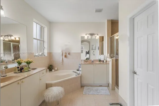 a bathroom with a tub sink and mirror