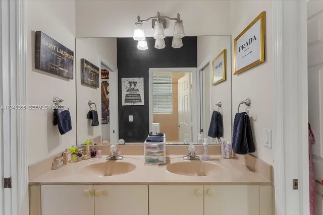 a bathroom with double vanity sinks a vanity and a mirror