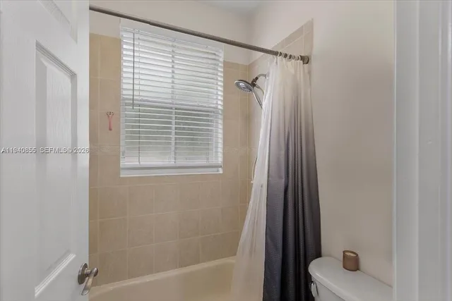 a bathroom with a tub a sink and a window