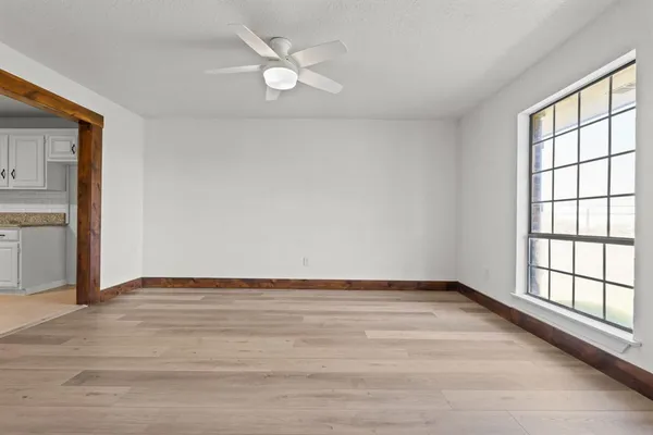 a kitchen with stainless steel appliances granite countertop a stove top oven a sink dishwasher and white cabinets with wooden floor