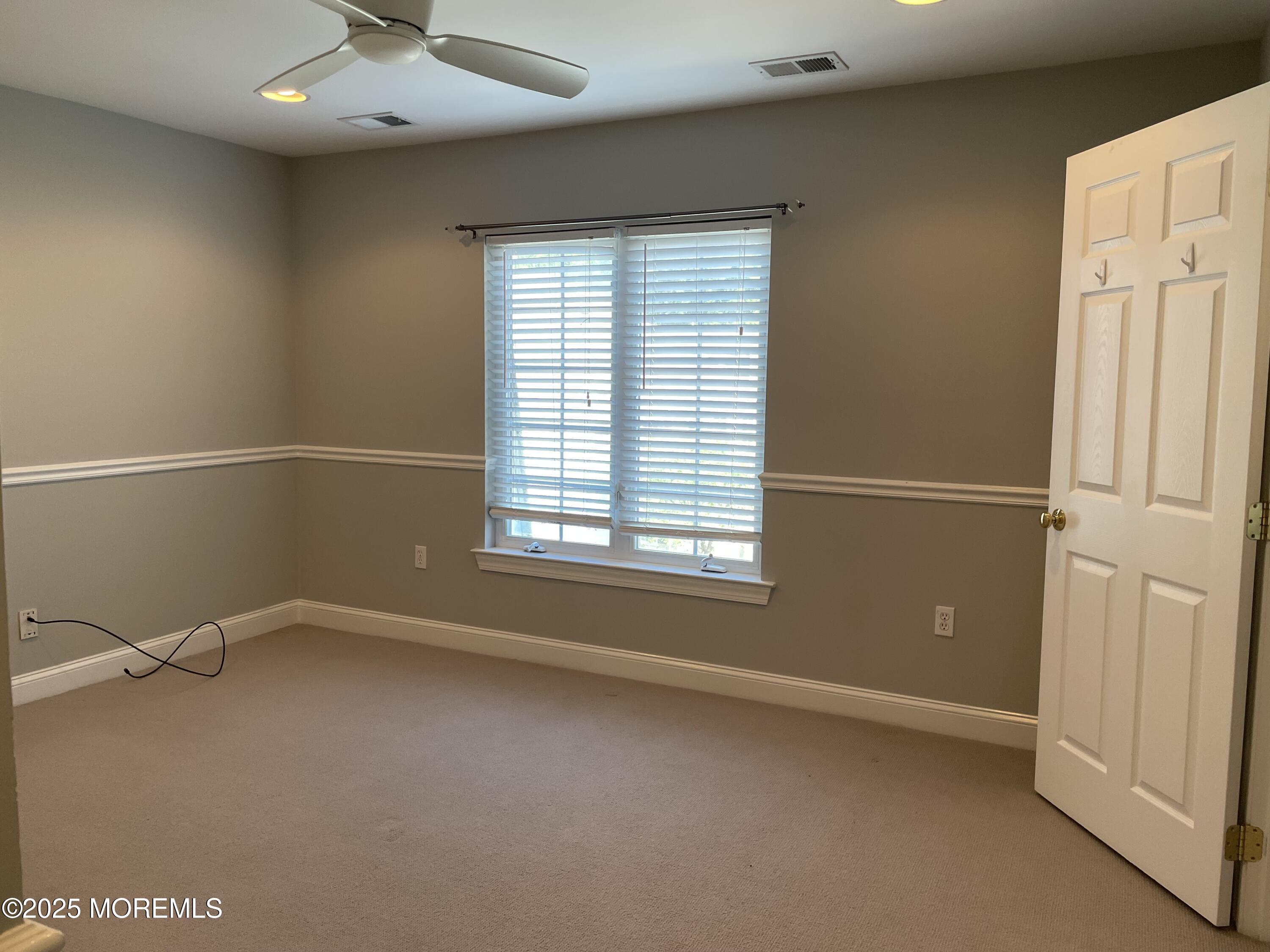 508 Abby Road Middletown, NJ 07748 - Photo 8 of 17 an empty room with a window and a ceiling fan