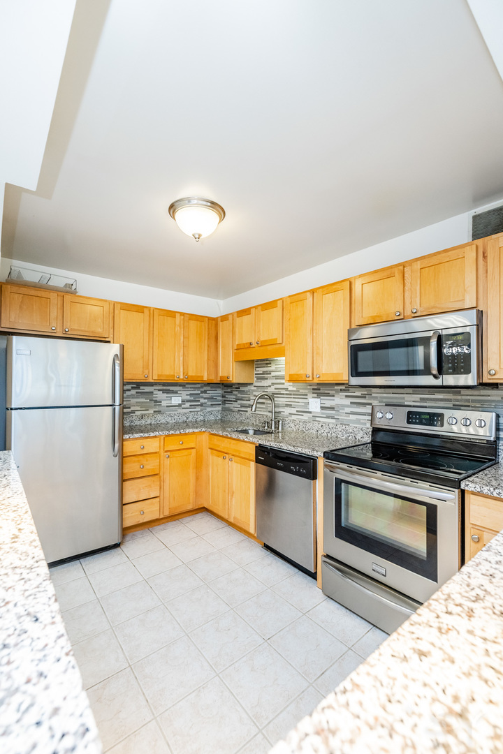 211 East Ohio Street, Unit 2606 Chicago, IL 60611 - Photo 13 of 32 a kitchen with stainless steel appliances granite countertop a stove and a sink