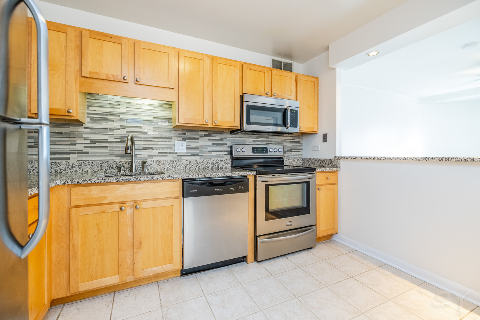 211 East Ohio Street, Unit 2606 Chicago, IL 60611 - Photo 14 of 32 a kitchen with stainless steel appliances granite countertop a stove a sink and a microwave