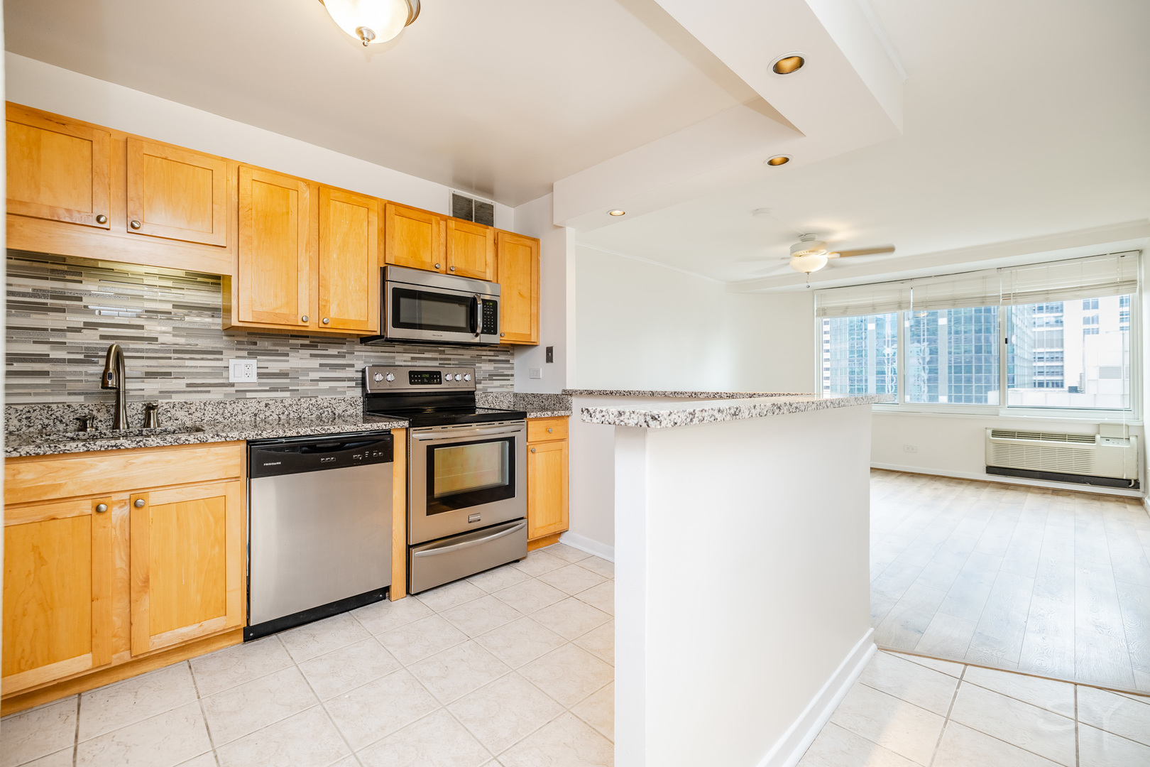 211 East Ohio Street, Unit 2606 Chicago, IL 60611 - Photo 15 of 32 a kitchen with granite countertop a stove top oven sink and cabinets