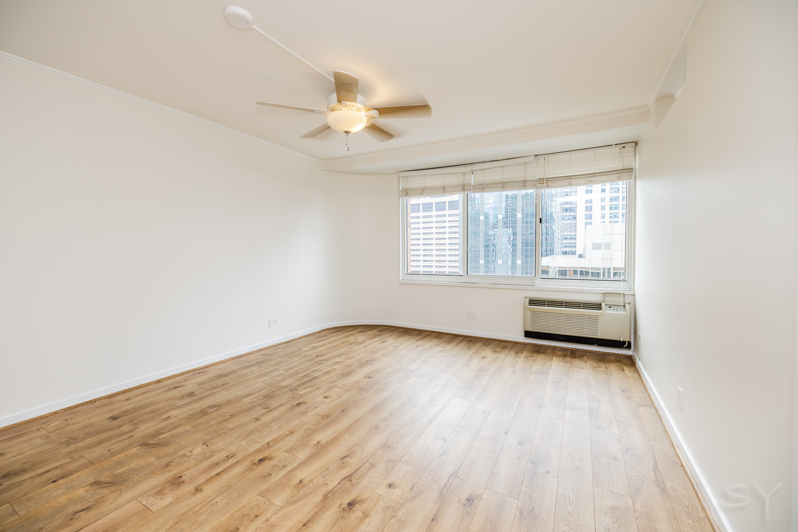 211 East Ohio Street, Unit 2606 Chicago, IL 60611 - Photo 16 of 32 an empty room with wooden floor fan and windows