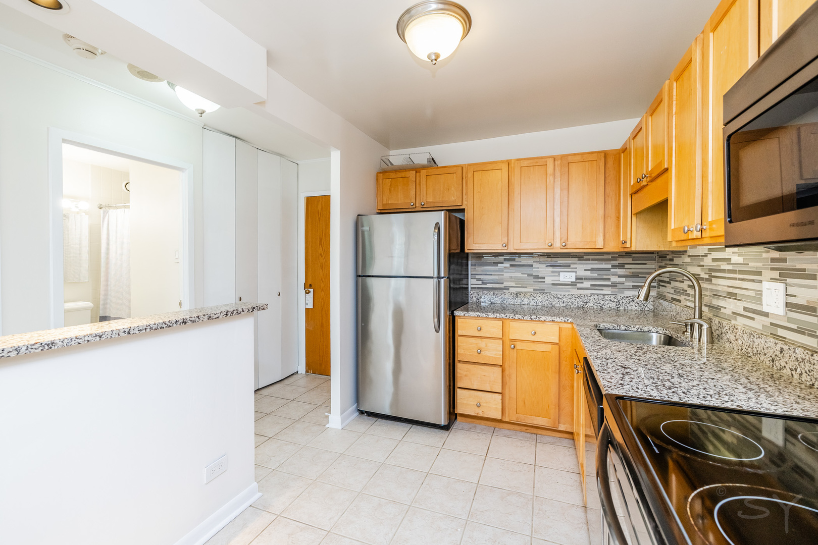 211 East Ohio Street, Unit 2606 Chicago, IL 60611 - Photo 28 of 32 a kitchen with stainless steel appliances granite countertop a refrigerator a stove a sink and a microwave