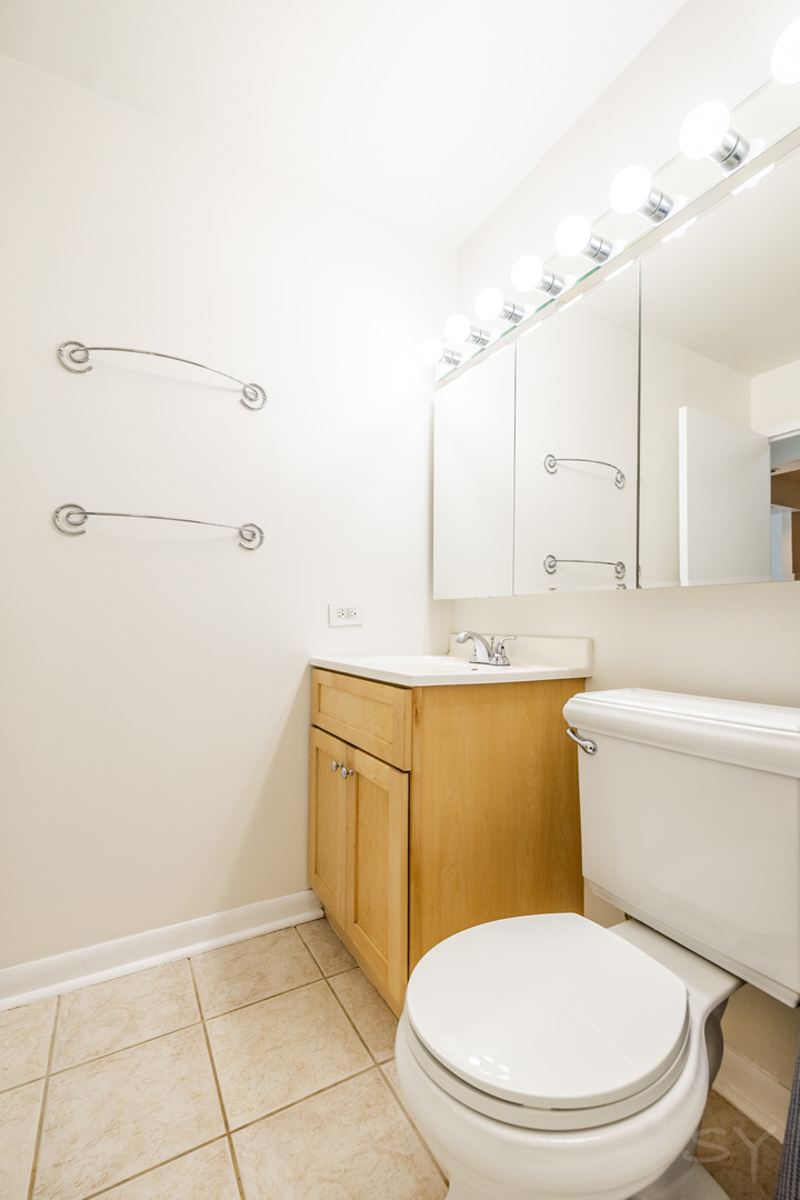211 East Ohio Street, Unit 2606 Chicago, IL 60611 - Photo 31 of 32 a bathroom with a toilet a sink and mirror