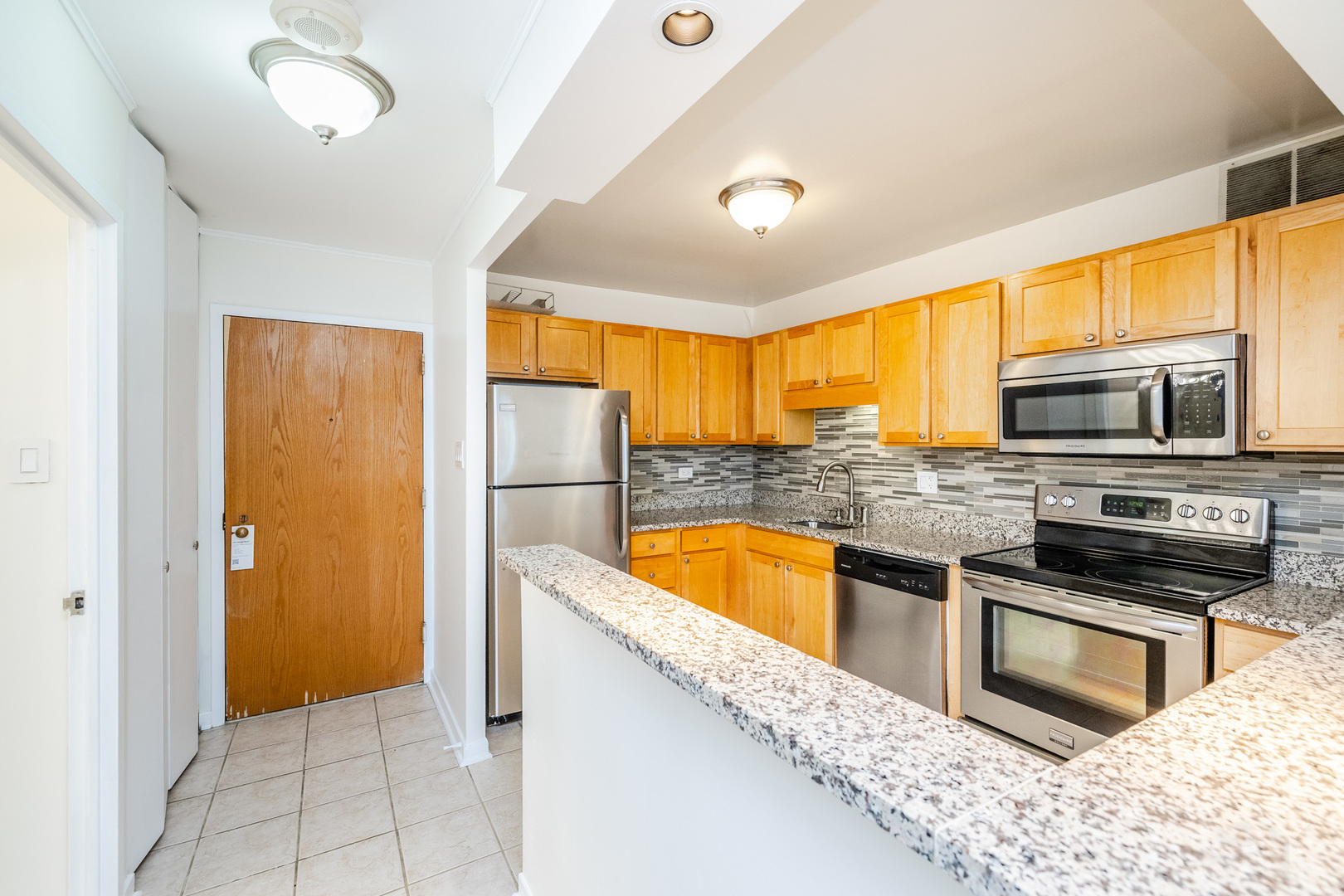 211 East Ohio Street, Unit 2606 Chicago, IL 60611 - Photo 10 of 32 a kitchen with stainless steel appliances granite countertop a refrigerator and a sink