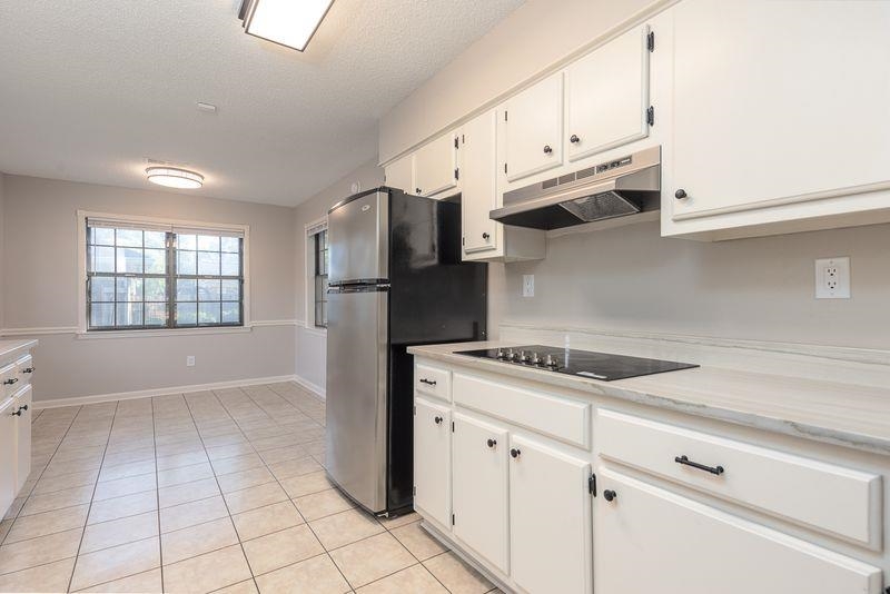 1780 Allenby Road Germantown, TN 38139 - Photo 11 of 26 a kitchen with granite countertop white cabinets and white appliances
