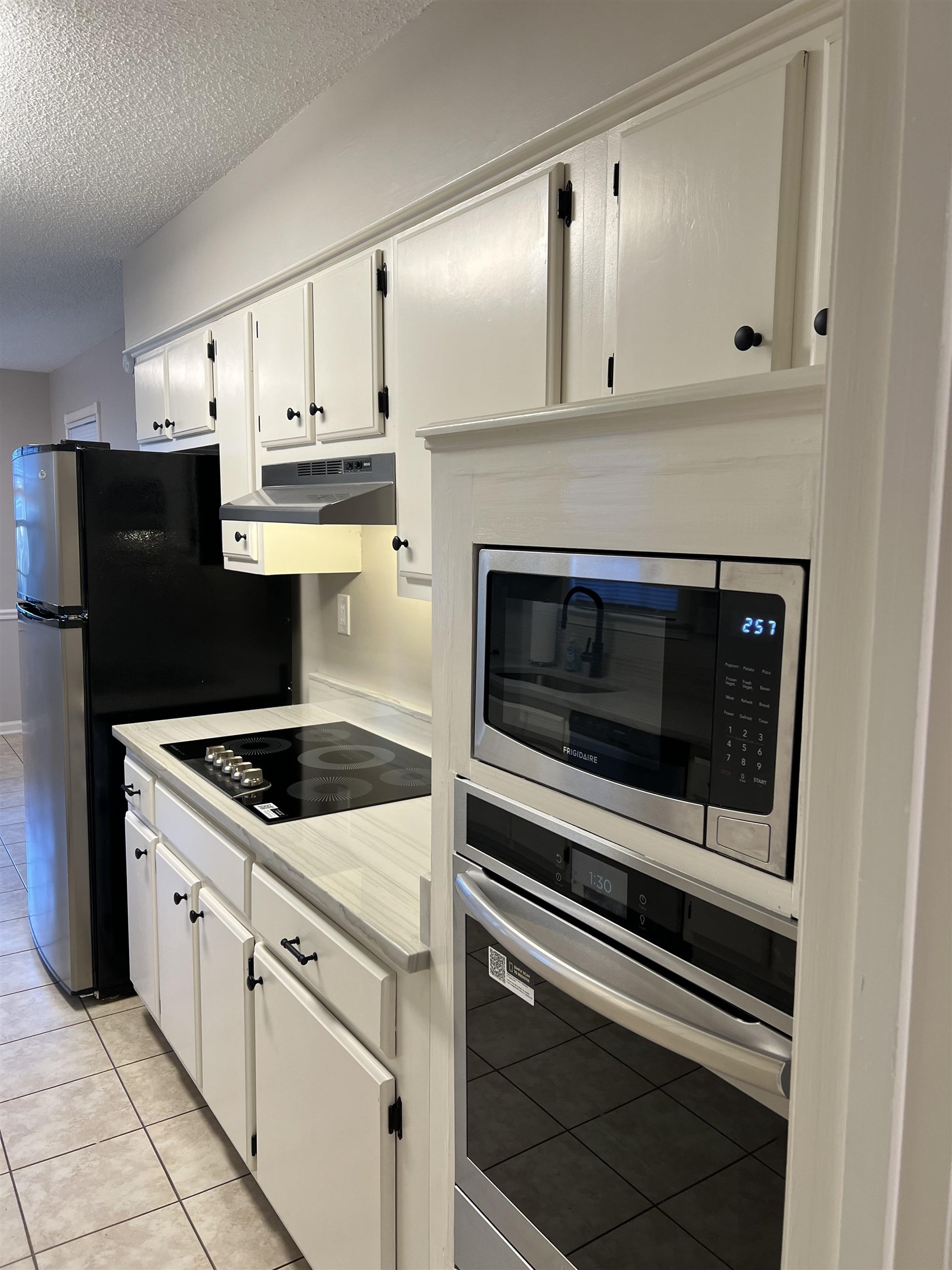 1780 Allenby Road Germantown, TN 38139 - Photo 25 of 26 a kitchen with white cabinets and black appliances