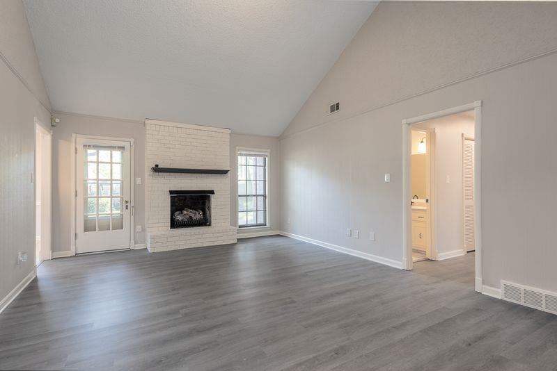 1780 Allenby Road Germantown, TN 38139 - Photo 8 of 26 an empty room with wooden floor fireplace and windows