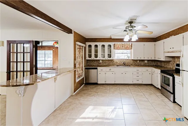 a large kitchen with a stove a sink dishwasher and a refrigerator