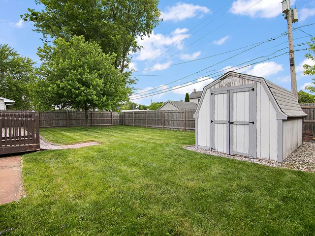 a view of backyard with wooden fence