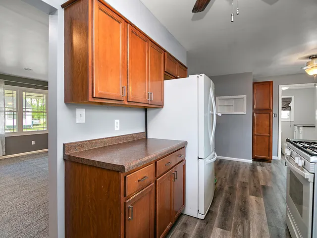 a kitchen with a refrigerator a sink and wooden cabinets