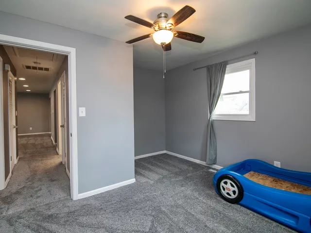 a view of empty room with window and ceiling fan