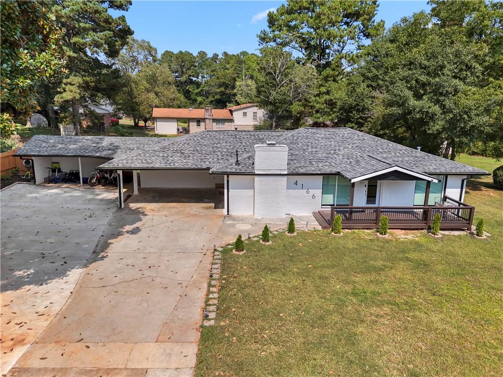 a view of a house with a large tree and a yard