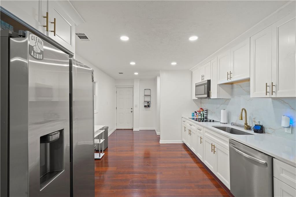 4166 Idlevale Drive Tucker, GA 30084 - Photo 24 of 36 a kitchen with stainless steel appliances a refrigerator sink and white cabinets