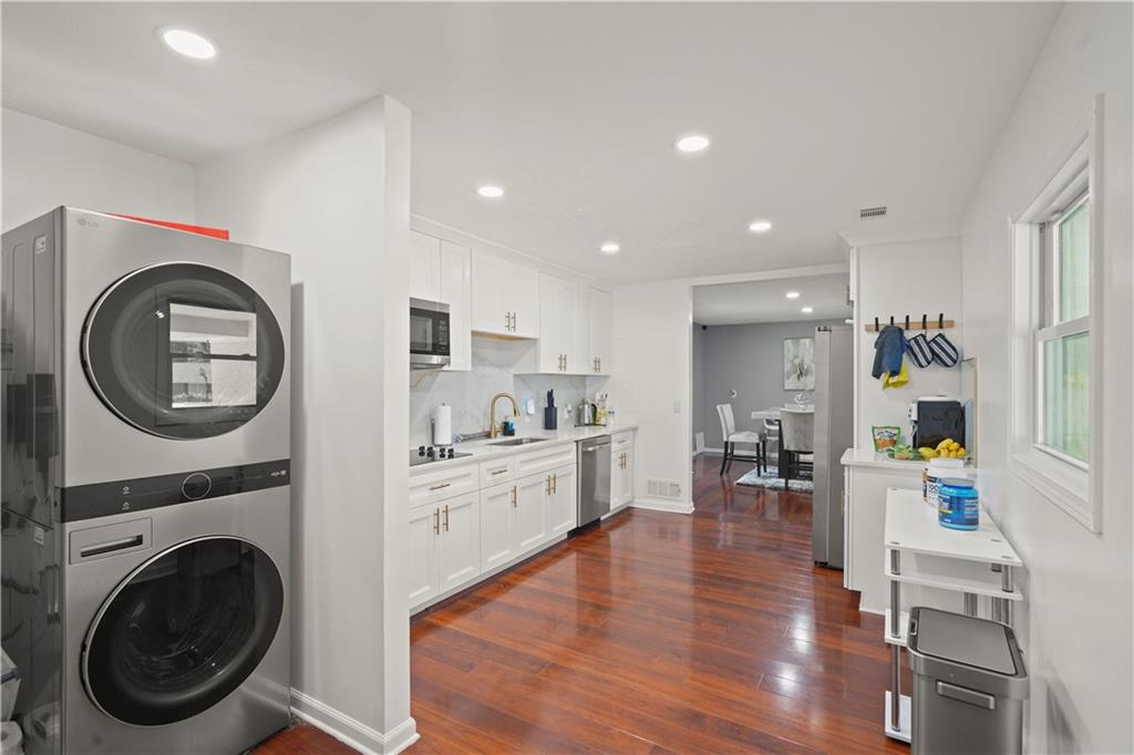 4166 Idlevale Drive Tucker, GA 30084 - Photo 25 of 36 a living room with stainless steel appliances kitchen island wooden floors and fireplace