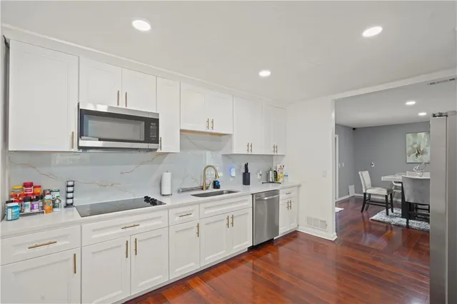 a kitchen with a sink cabinets and wooden floor