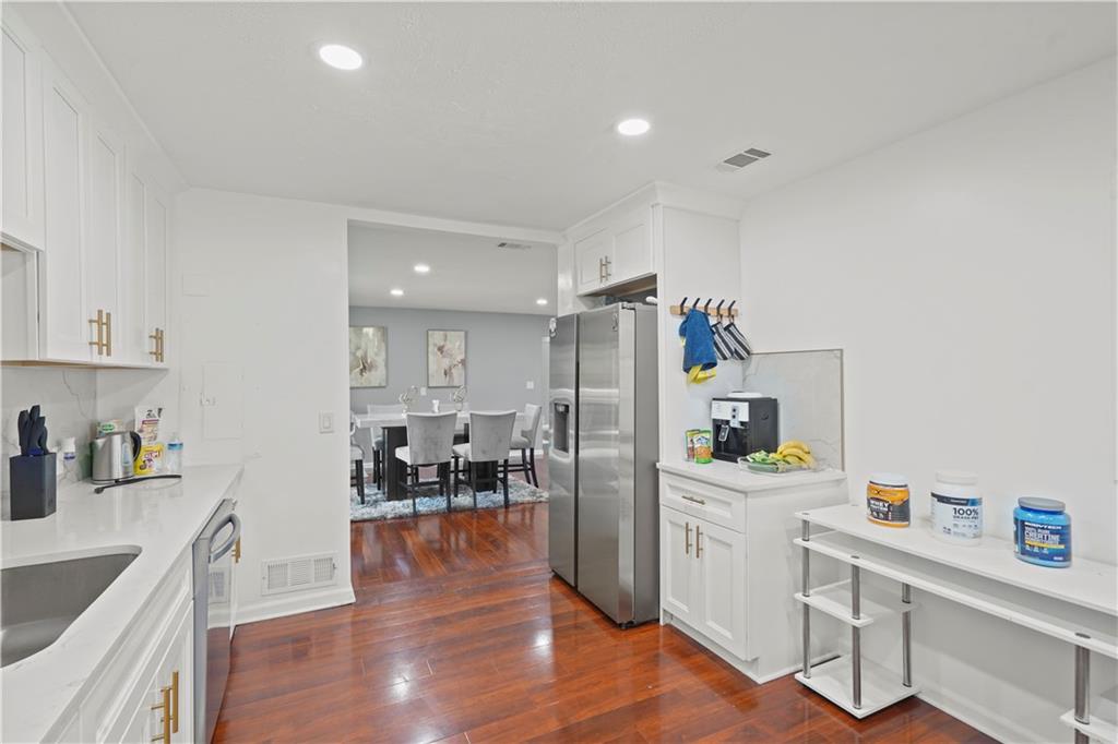 4166 Idlevale Drive Tucker, GA 30084 - Photo 28 of 36 a kitchen with stainless steel appliances a stove a sink a refrigerator cabinets and wooden floor