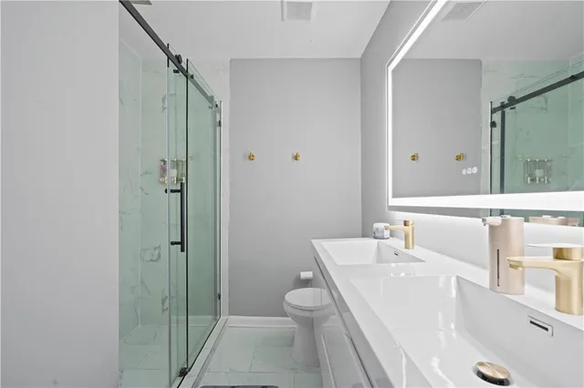 a bathroom with a sink a toilet and shower