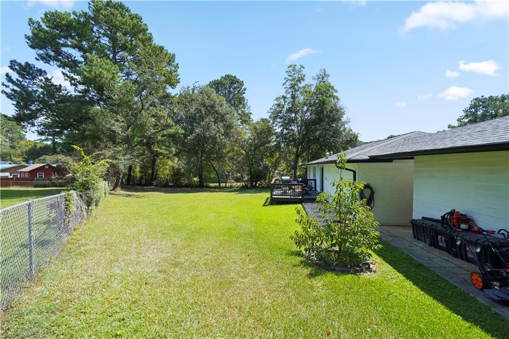 4166 Idlevale Drive Tucker, GA 30084 - Photo 34 of 36 a view of a backyard with couches under an umbrella