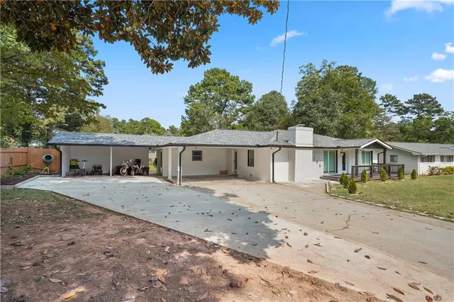 a view of a house next to a yard with large tree