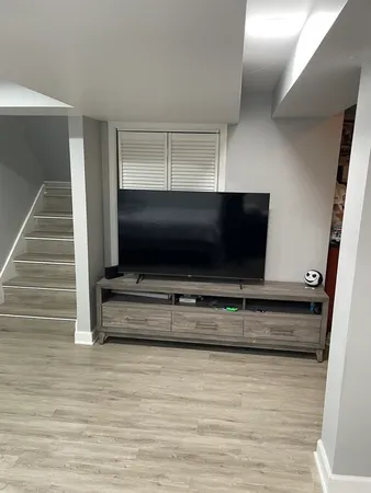 a living room with a flat screen tv and a walk in closet