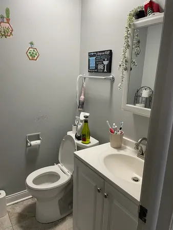 a bathroom with a toilet sink and mirror