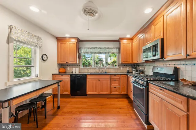a kitchen with stainless steel appliances granite countertop a refrigerator a stove top oven a sink and dishwasher