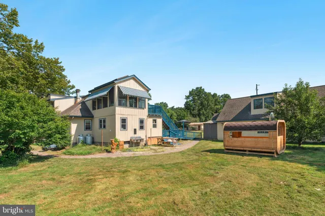 a view of backyard with small cabin and wooden fence
