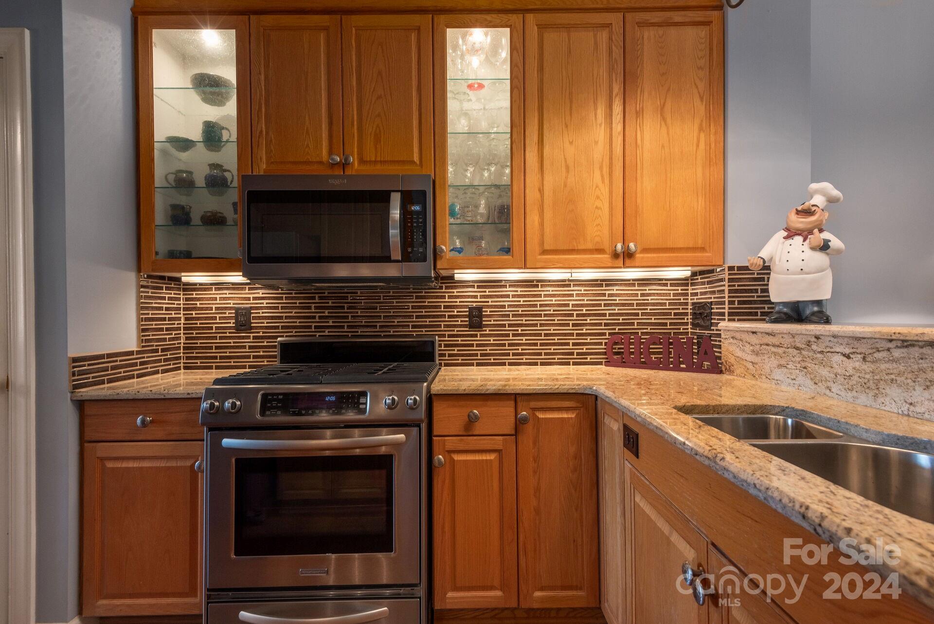 3322 Stettler View Road Charlotte, NC 28210 - Photo 7 of 27 a kitchen with granite countertop a stove top oven microwave and cabinets