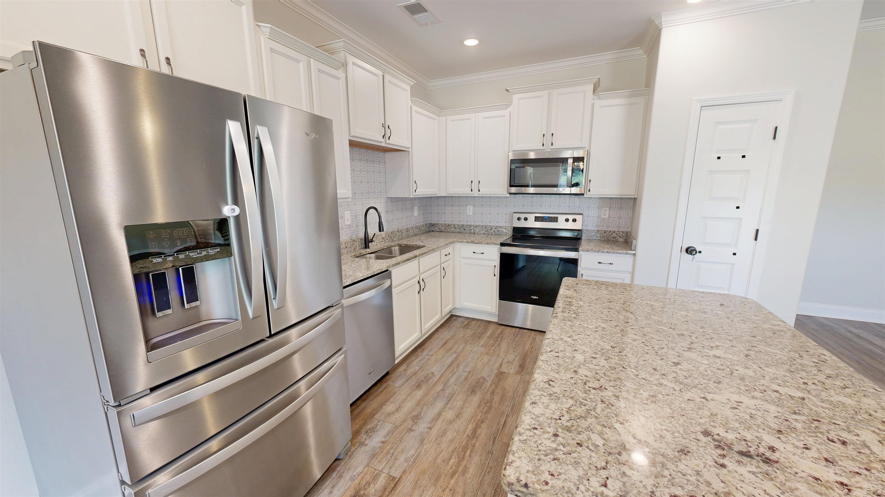 5217 Nail Road Olive Branch, MS 38654 - Photo 11 of 35 Kitchen with appliances with stainless steel finishes, light wood-style flooring, white cabinets, backsplash, and light stone countertops