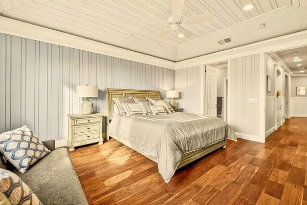 a spacious bedroom with a bed and a dresser