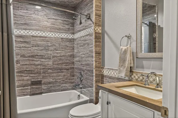 a bathroom with a granite countertop sink toilet and shower