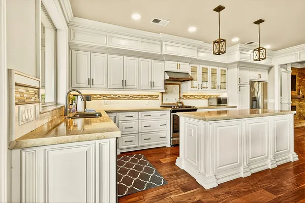 a kitchen with stainless steel appliances granite countertop a sink stove and cabinets