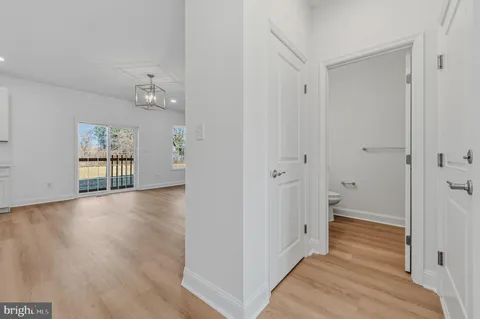 a view of a hallway with wooden floor and closet area