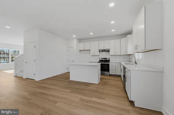 a kitchen with a refrigerator and white cabinets