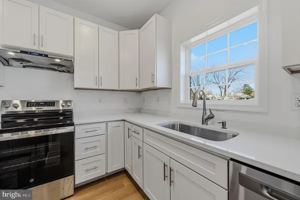 a kitchen with white cabinets and a stove top oven