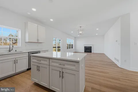 a kitchen with white cabinets and sink