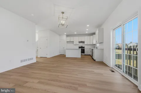 a view of a kitchen with a sink and wooden floor
