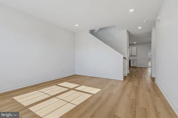 an empty room with wooden floor and white walls